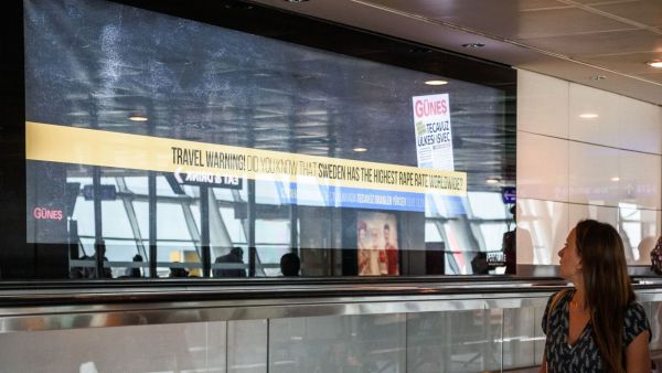 Passenger reads a billboard that reads, 'Travel warning - Do you know that Sweden has the highest rape rate worldwide? (AFP/Fulya Ozerkan)