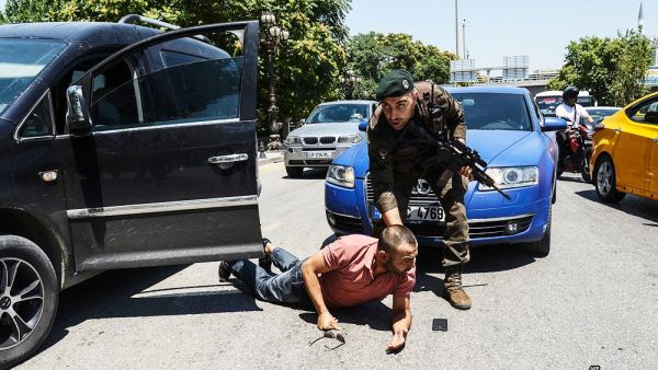The Turkish policeman restrains a man during an operation in front of a courthouse in Ankara. (Twitter)