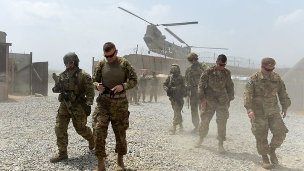 U.S. Army soldiers walk as a NATO helicopter flies overhead at coalition force Forward Operating Base (FOB) Connelly in the Khogyani district in the eastern province of Nangarhar on August 13, 2015. (AFP/Wakil Kohsar)
