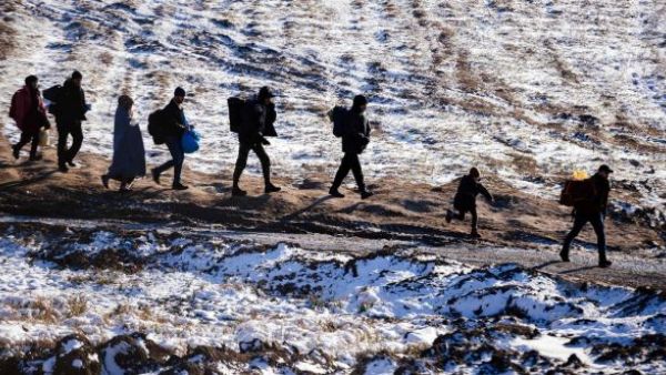 Migrants and refugees walk along snow-covered fields after crossing the Macedonian border into Serbia. (AFP/File)