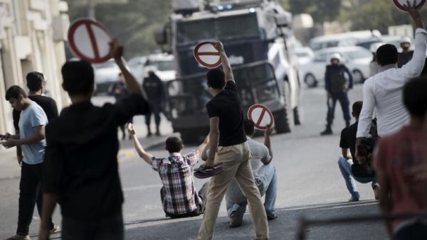 Bahraini youth holding signs calling for the boycott of the parliamentary elections, during a rally in the village of Diraz, west of Manama on November 21, 2014. (AFP/Mohammed al-Shaikh)