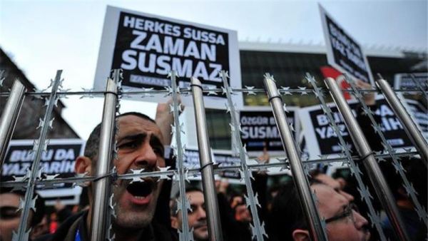 Staff members and supporters of Zaman newspaper shout slogans and hold placards reading 'Free press'. (AFP/File)