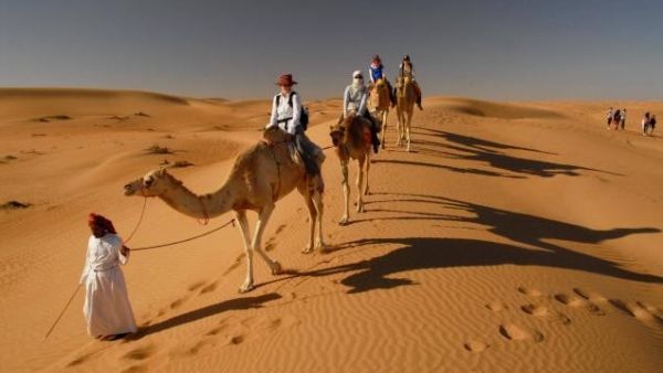 Tourists take a camel ride to visit the Bedouin village at Wahiba Sands. (Oman Tourism Ministry)