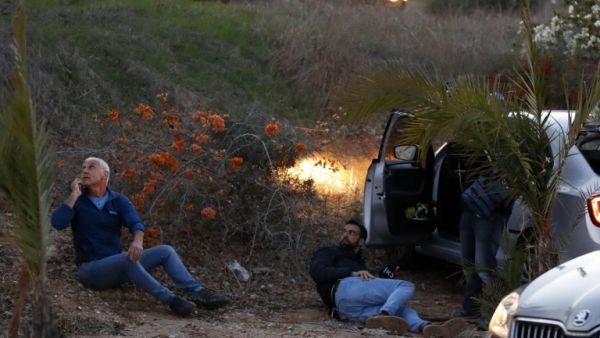 Israelis take cover as rockets are fired from the Gaza Strip, in the southern Israeli town of Sderot on November 12, 2018. (Jack GUEZ / AFP)