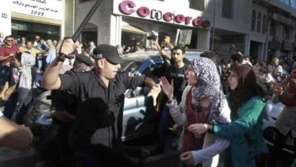 صورة عن الفيسبوك لرجل شرطة يهدد احدى المتظاهرات