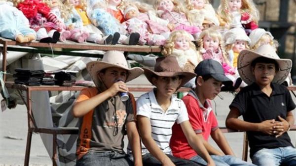 اطفال فلسطينيون يبيعون دمى قرب حاجز الجلمة في الضفة الغربية/أ.ف.ب