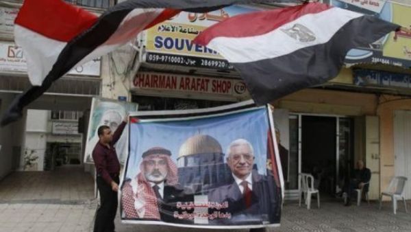 فلسطيني يعرض صورة كبيرة لرئيس الحكومة المقالة اسماعيل هنية ورئيس السلطة الفلسطينية محمود عباس بعد اعلان التوصل الى اتفاق مصالحة