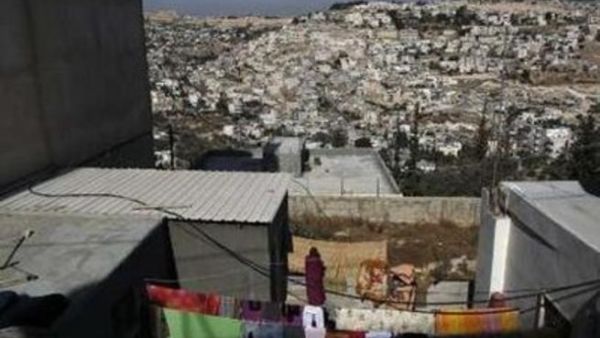 امراة فلسطينية تقف في منزلها قبالة جبل المكبر في القدس الشرقية