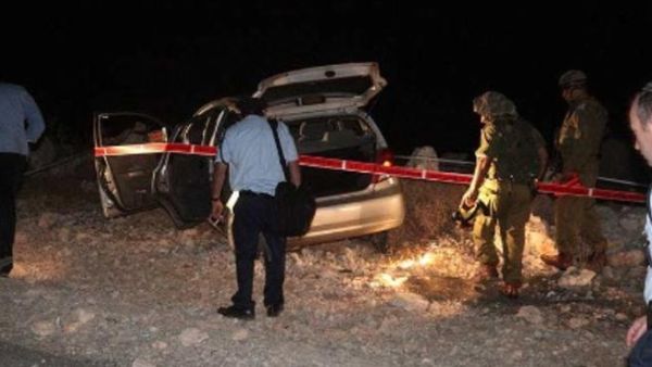 عناصر من الامن الاسرائيلي يتفقدون السيارة التي تعرضت للهجوم قرب رام الله