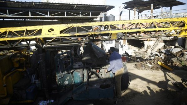 A Palestinian man surveys a damaged vehicle after an Israeli airstrike on Gaza on May 5, 2016. (AFP/Mohammed Abed)