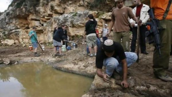 مستوطنون اسرائيليون يستولون على نبع مياه في قرية كراوة بني حسان قرب نابلس تحت حماية الجيش الاسرائيلي/أ.ف.ب/ارشيف