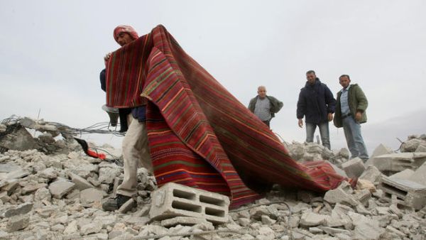 فلسطيني يسحب سجادة من ركام مسجد دمرته اسرائيل بحجة مخالفة تعاليم البناء في الضفة الغربية/أ.ف.ب