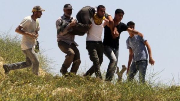 فلسطينيون يسعفون جريحا اصيب في المواجهات مع المستوطنيين في الضفة/أ.ف.ب