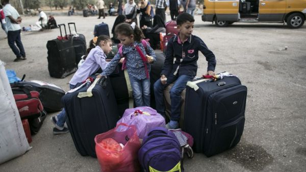 Palestinian children wait as they wait to cross with their families into Egypt through the Rafah border crossing on October 16, 2016 in the southern Gaza Strip. (AFP/Said Khatib)