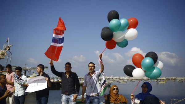 Palestinians show their solidarity with a Gaza-bound flotilla of international activists attempting to break the Israeli blockade on the Hamas-run Gaza Strip, on October 5, 2016 at the port in Gaza City. (AFP/Mohammed Abed)