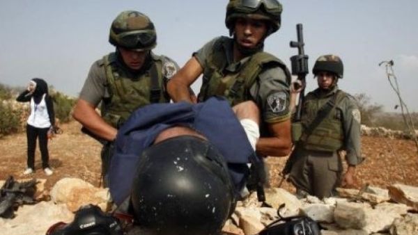 Israeli soldiers detain a Palestinian journalist during a demonstration. (AFP/File)