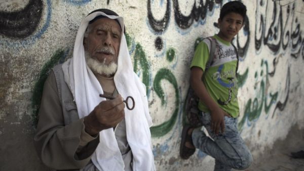 Ibrahim Abu Mustaf, 83, who says he is a former inhabitant of the town of Beersheva, carries the key to his former home in the Khan Yunis refugee camp in the southern Gaza Strip on May 15, 2016, on the 68th anniversary of the Nakba. (AFP/Said Khatib)