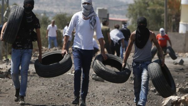 Palestinian protestors burn tires during clashes with Israeli security forces following a weekly demonstration against the expropriation of Palestinian land by Israel in the village of Kfar Qaddum, near Nablus in the occupied West Bank, on September 9, 2016. (AFP/Jaafar Ashtiyeh)