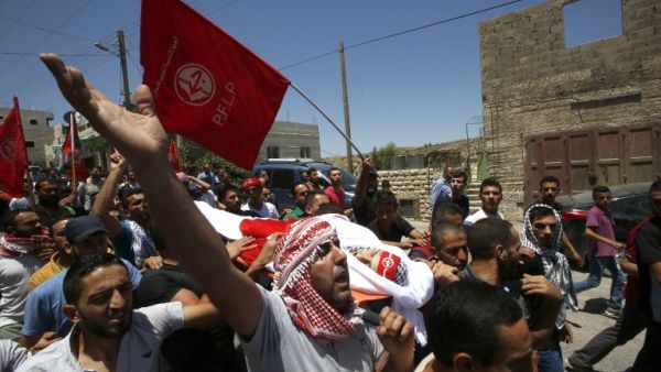 Palestinian mourners carry the body of Aref Jaradat, a 22-year old Palestinian during his funeral in Sair village east of the West Bank city of Hebron on June 20, 2016. (AFP/Hazem Bader)