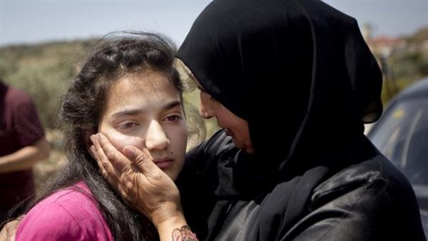Palestinian 12-year-old Dima al-Wawi, imprisoned by Israel for allegedly attempting to carry out a stabbing attack, is greeted by her mother Sabha al-Wawi and her father Ismail al-Wawi after her release from an Israeli prison, at Jabara checkpoint near the West Bank town of Tulkarem on April 24, 2016. (Twitter/Press TV)
