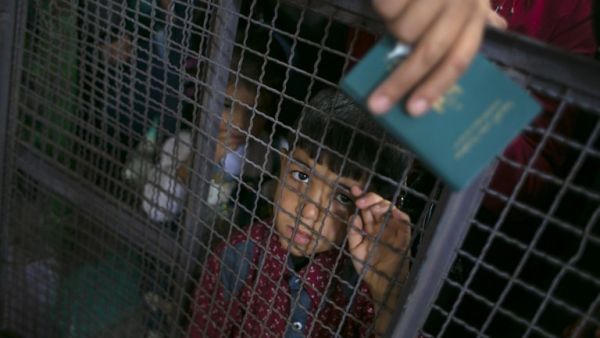 A Palestinian child looks through a barrier as he waits at the Rafah border crossing with Egypt, in the southern Gaza Strip, after it was opened for two days by Egyptian authorities, on May 11, 2016. (AFP/Said Khatib)