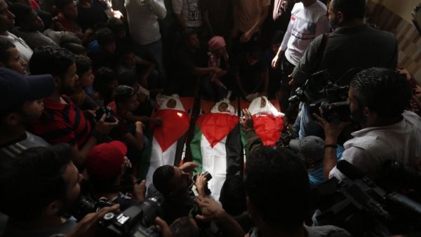 Palestinian mourners gather around the bodies of three Palestinian teenagers killed last night in an Israeli strike. (AFP/ MAHMUD HAMS)