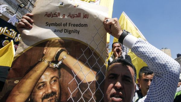 A Palestinian protester carries the image of Marwan Barghouti. (AFP/file)