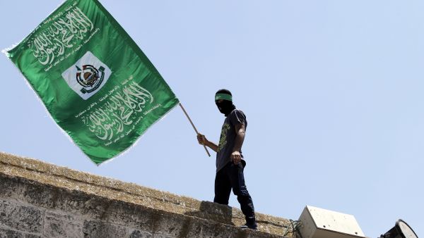 In a file photo, a demonstrator carries a Hamas flag on the roof of occupied Jerusalem's Al-Aqsa mosque, June 3 2015. (AFP/Ahmad Gharabli)