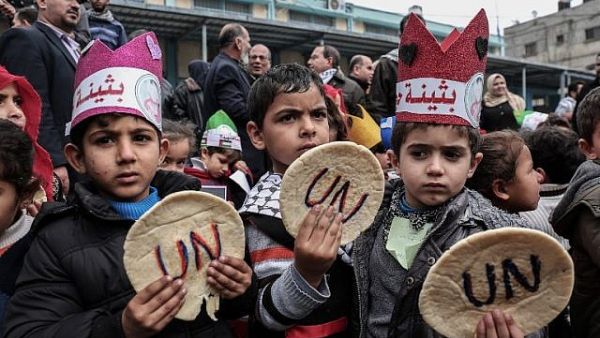 Palestinian children hold bread patties during a protest against aid cuts, outside the United Nations' offices in Khan Yunis in the southern Gaza Strip on January 28, 2018. (Said Khatib/AFP)