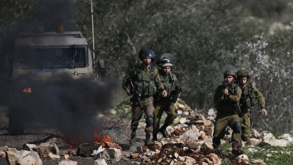 Israeli soldiers keep position during clashes with Palestinian protestors following a weekly demonstration against the expropriation of Palestinian land by Israel in the village of Kfar Qaddum, near Nablus, in the occupied West Bank on February 10, 2017. (AFP/Jaafar Ashtiyeh)