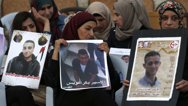 Palestinian women hold portraits of relatives imprisoned in Israeli jails during a protest in front of the Red Cross offices in east Jerusalem on May 25, 2017. The hunger strike was called off on May 27. (Ahmad Gharabli/AFP)