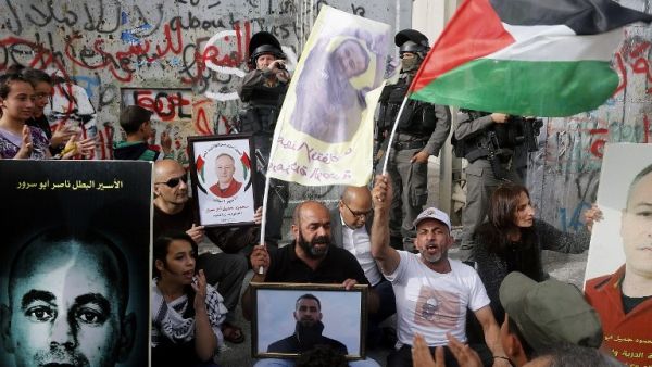 Palestinians protest in solidarity with security prisoners on a hunger strike by the security barrier in the West Bank city of Bethlehem on April 26, 2017. (AFP/Musa Al Shaer)