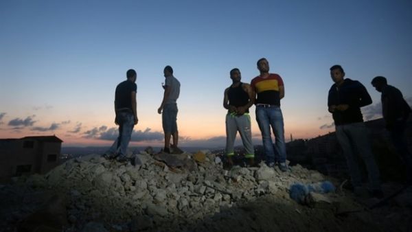 Palestinians stand on the rubble of a house which was demolished by Israeli forces during an overnight raid in the West Bank city of Jenin, Sept. 1, 2015. (AFP/Jaafar Ashtiyeh)