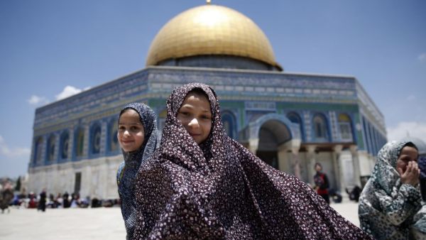 Palestinian girls stand in front the Dome of the Rock as they attend the first Friday prayers of the Muslim holy month of Ramadan at Jerusalem's al-Aqsa mosque compound on June 2, 2017. (AFP/Ahmad Gharabli)