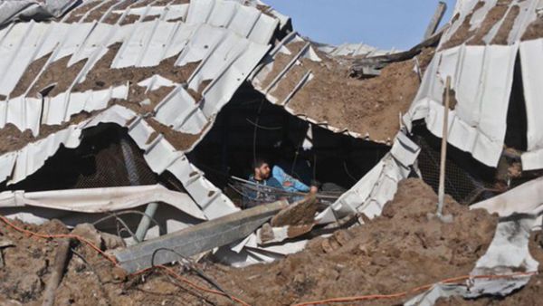 Palestinians try to pull out chickens after a roof collapsed over livestock in the strike. (Twitter)