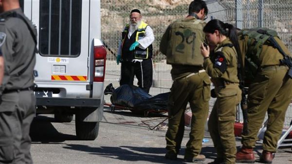 Israeli forces stand next to the body of a Palestinian who was shot dead following an alleged attempt to stab Israeli border police, at a checkpoint near the Israeli settlement of Har Homa in the occupied West Bank. (AFP/File) 