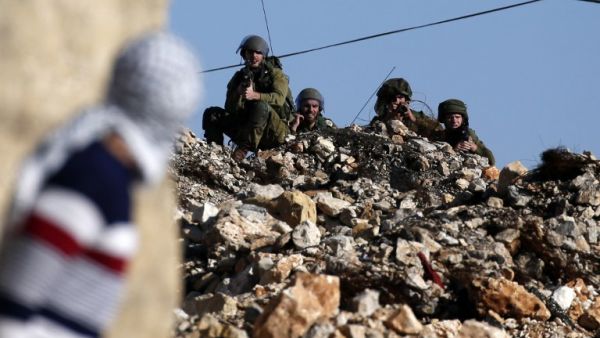 A Palestinian protestor looks towards Israeli security forces during clashes following a demonstration against the expropriation of Palestinian land by Israel in the village of Kfar Qaddum, near Nablus, in the occupied West Bank on January 6, 2017. (AFP/Jaafar Ashtiyeh)