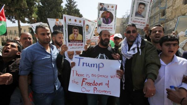 Palestinian protesters shout slogans and hold placards outside the Church of the Nativity in Bethlehem during a demonstration in support of prisoners refusing food in Israeli jails, on May 23, 2017, during a visit of the US president to the West Bank town. (AFP/Hazem Bader)