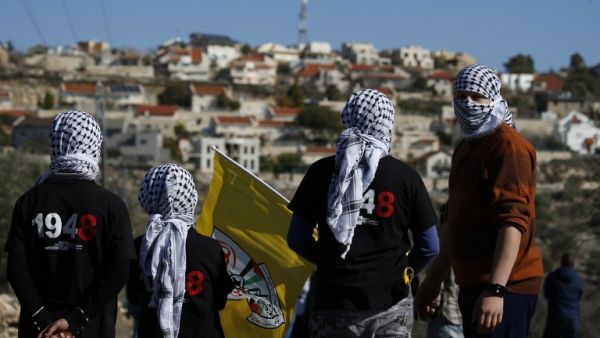 This file photo taken on December 30, 2016 shows Palestinian protestors stand facing the Israeli settlement of Qadumim (Kedumim) during clashes with Israeli security forces following a demonstration against the expropriation of Palestinian land by Israel in the village of Kfar Qaddum, near Nablus, in the occupied West Bank. (AFP/Jaafar Ashtiyeh)