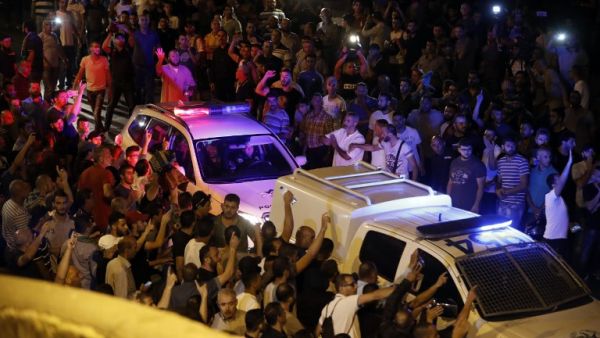 Palestinian demonstrators attempt the block the road ahead of Israeli police cars outside Lions' Gate, a main entrance to the Al-Aqsa mosque compound in Jerusalem's Old City, on July 22, 2017 (AFP)