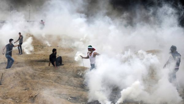 Palestinian protesters flee from teargas fumes during clashes with Israeli forces along the border with the Gaza strip east of Gaza City, on the sixth straight Friday of mass demonstrations calling for the right to return to their historic homeland. (MAHMUD HAMS/ AFP)