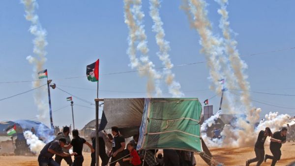 Palestinians run for cover from tear gas near the border between Israel and the Gaza Strip, east of Jabalia. (Mohammed ABED/ AFP)