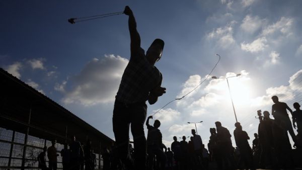 A Palestinian protestor hurls a rock during a demonstration at the Erez crossing with Israel on September 18, 2018, in the northern Gaza Strip. (Said KHATIB / AFP)