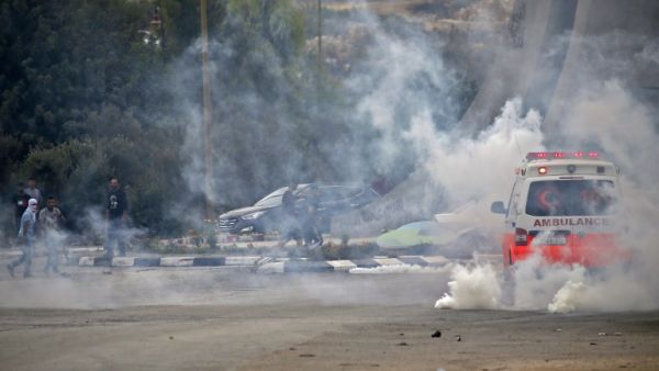 Palestinian protesters react to tear gas fired by Israeli forces during clashes near the Israeli settlement of Beit El, on the outskirt of Ramallah, in the occupied West Bank on October 1, 2018.  (ABBAS MOMANI / AFP)