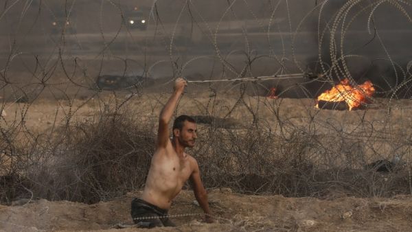 Disabled Palestinian Saber al Ashqar, aged 29, uses a slingshot to throw stones at Israeli forces during a demonstration near the border with Israel, east of Gaza City, on October 19, 2018. (MAHMUD HAMS / AFP)
