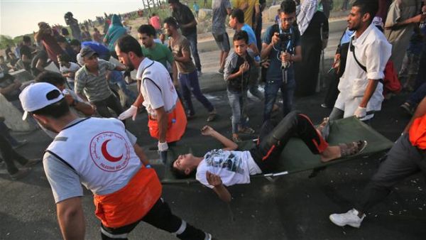 Palestinian paramedics carry an injured man as protesters demonstrate in the northern Gaza Strip on October 3, 2018. (AFP/File)