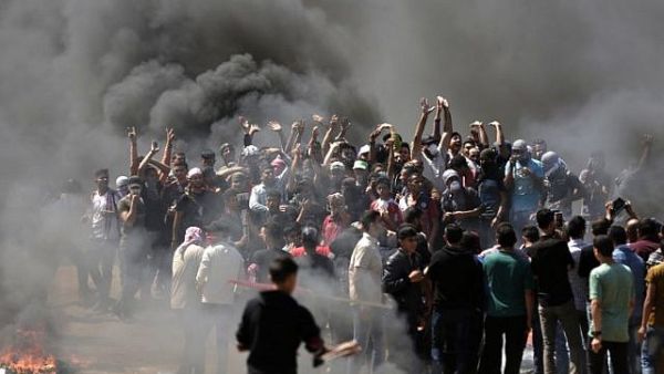 Palestinian demonstrators burn tires near the Gaza-Israel border, east of Gaza City, on May 14, 2018 (AFP/ File Photo, Mahmud Hams)