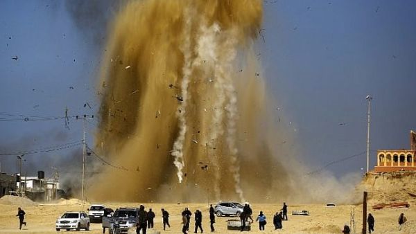 Palestinians run for cover as sand and smoke rise following an Israeli airstrike on a Hamas post in the northern Gaza Strip. (Mohammed Abed/ AFP)