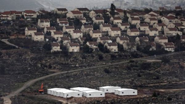 New prefabricated homes are seen under construction in the West Bank between the Israeli outpost of Amona and the settlement of Ofra (background), north of Ramallah, on January 31, 2017. (AFP/Thomas Coex)