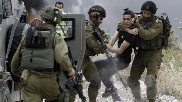 Israeli soldiers detain a Palestinian protester in the West Bank town of Tulkarem. (Jaafar Ashtiyeh/ AFP)